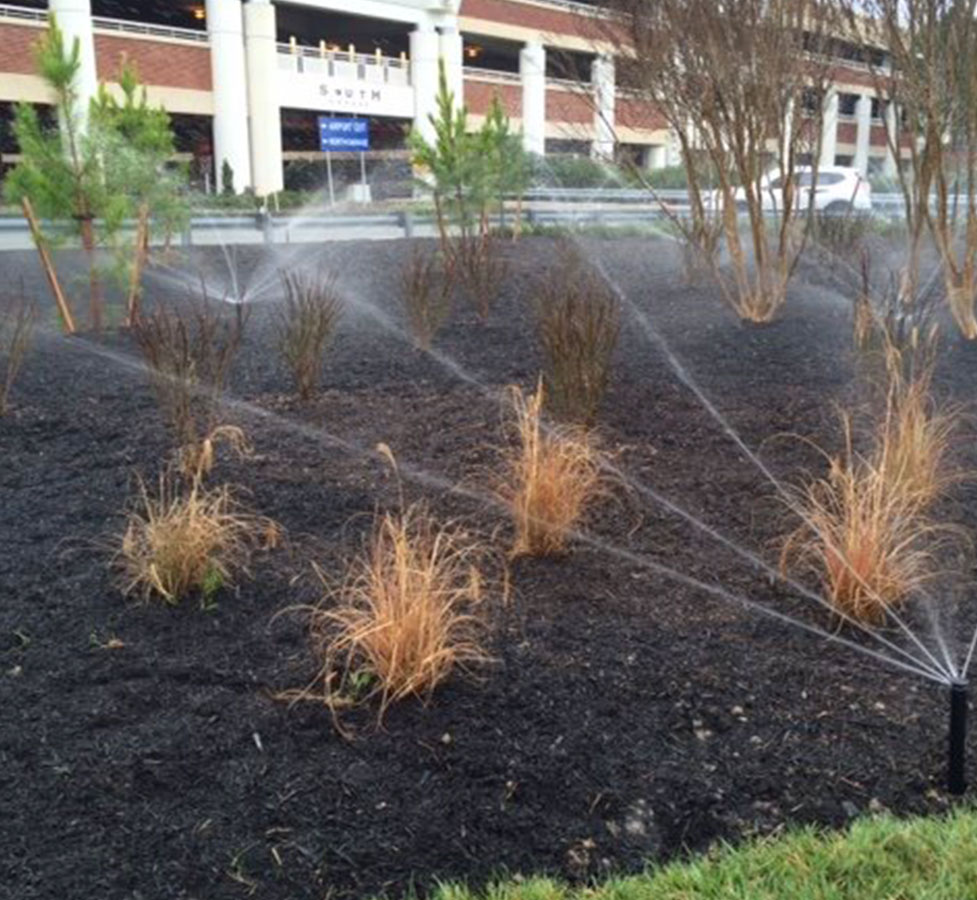 sprinklers watering commercial mulch